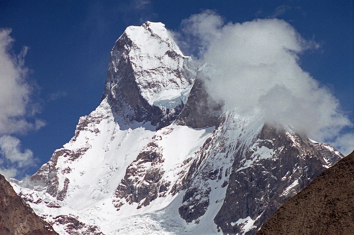 27 Muztagh Tower From Baltoro Glacier On Trek From Goro II to Concordia Taken from the upper Baltoro Glacier, the twin summits of Muztagh Tower (7274m) are perfectly aligned and the mountain is seen as a slender tooth, looking impregnable.  A similar photo by Vittorio Sella in 1909 inspired two expeditions to race for the first ascent in 1956. In reality both teams found their routes less steep than Sella's view had suggested. Joe Brown and Ian McNaught-Davis climbed from the west side of the peak and reached the west summit of Muztagh Tower (7270m) on July 6, 1956.  Tom Patey and John Hartog repeated the ascent the next day, also reaching the slightly higher east summit (7274m). A few days later a French Team of Guido Magnone, Robert Paragot, Andr Contamine, and Paul Keller climbed the mountain from the east.